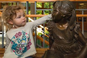 Little Girl with Arm Around Statue